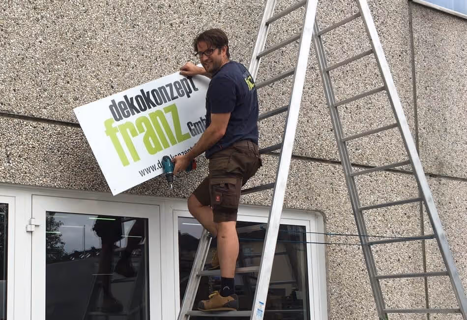 Ralf Franz montiert ein Schild