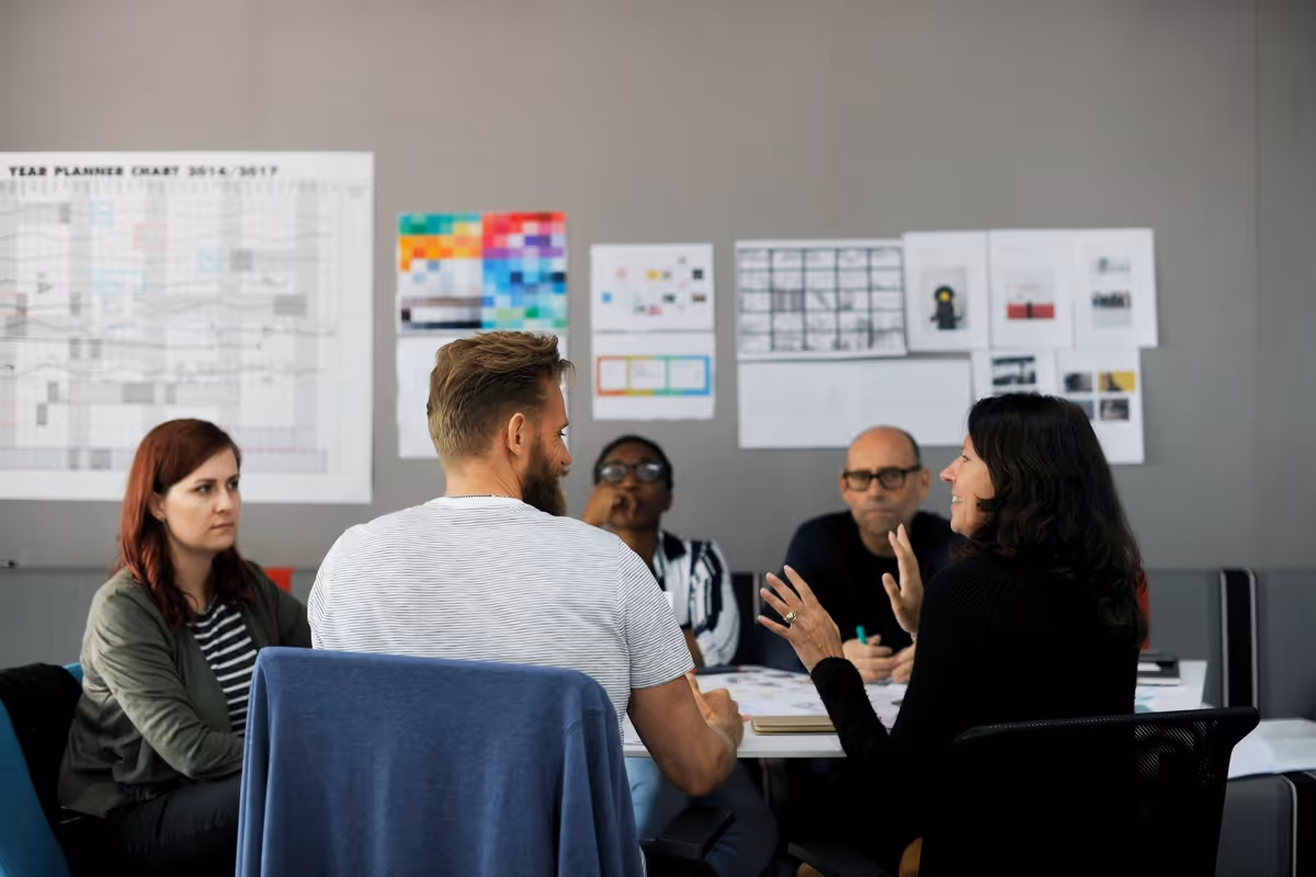 Image of people sat around a table in a wrokshop.