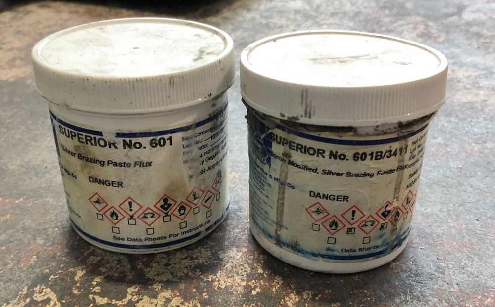 Two containers of welding flux