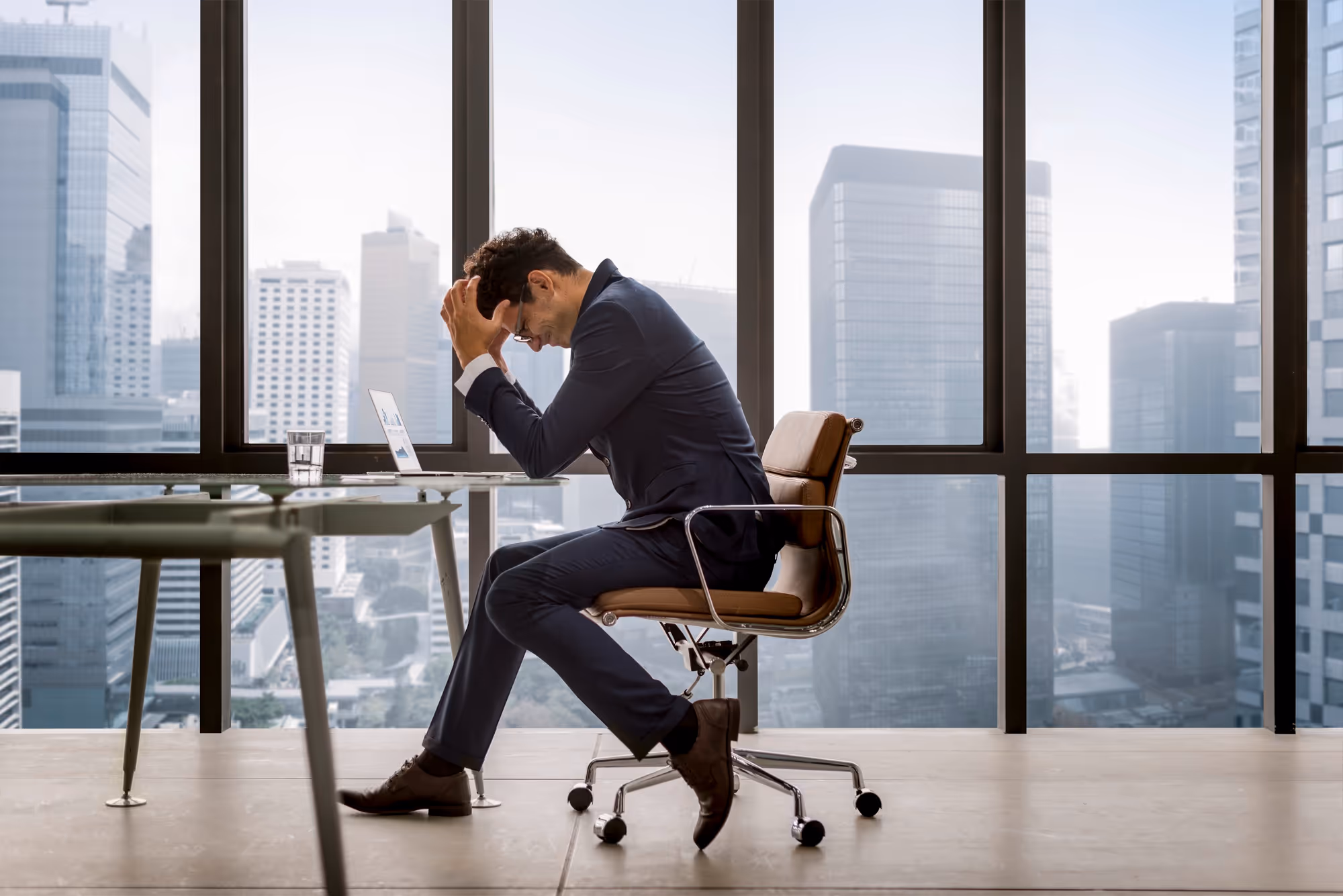 Business person being sad in front of a desk at the office