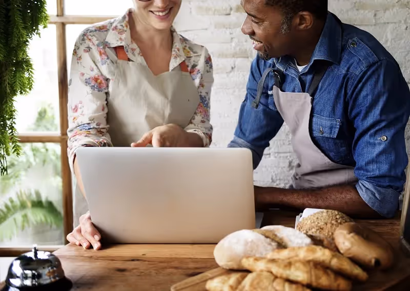 Bakery owners discussing business over a laptop.