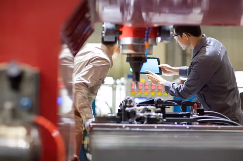 IT support services experts discuss data management and security controls in a factory.