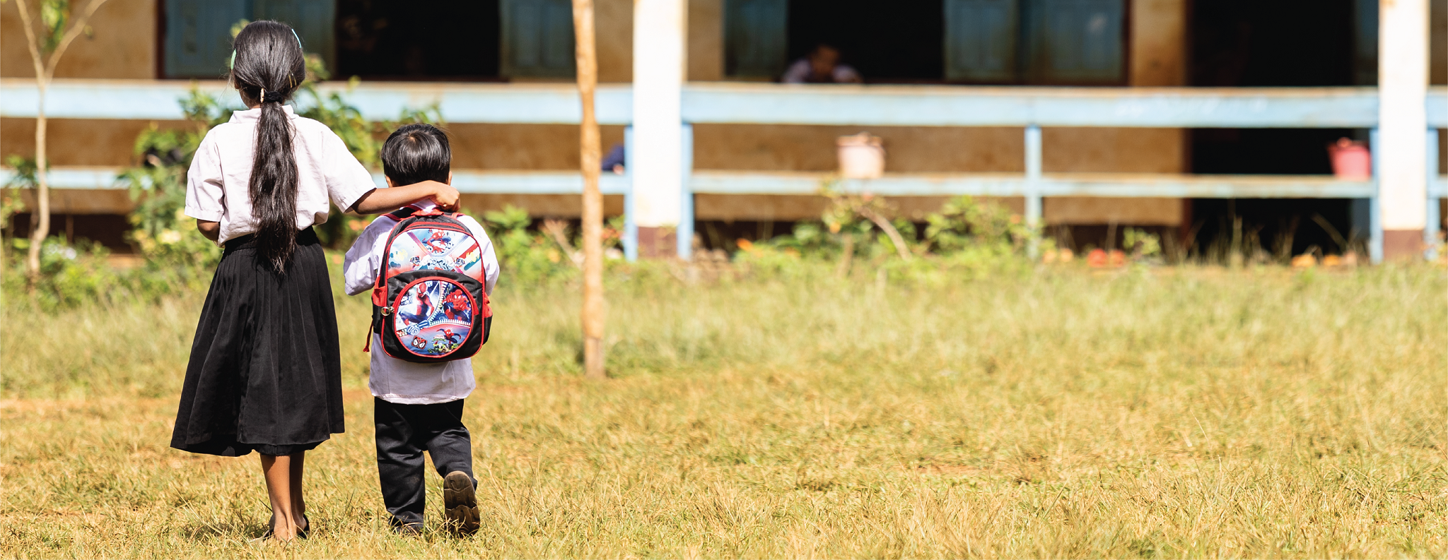 Deux jeunes enfants se rendent à l'école à pied, au Laos.