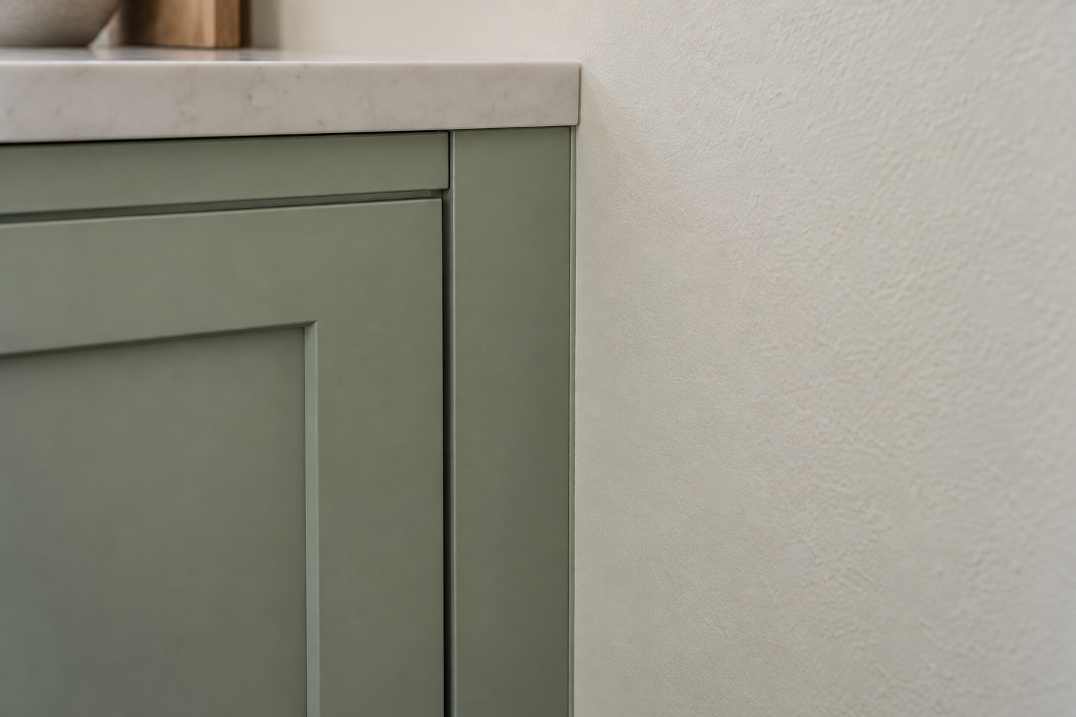 Green cabinet against a wall, sealed with color-matched caulk