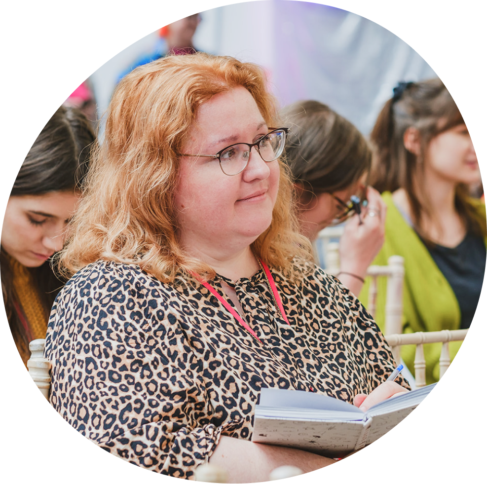 Women smiling making notes at UPFRONT conference