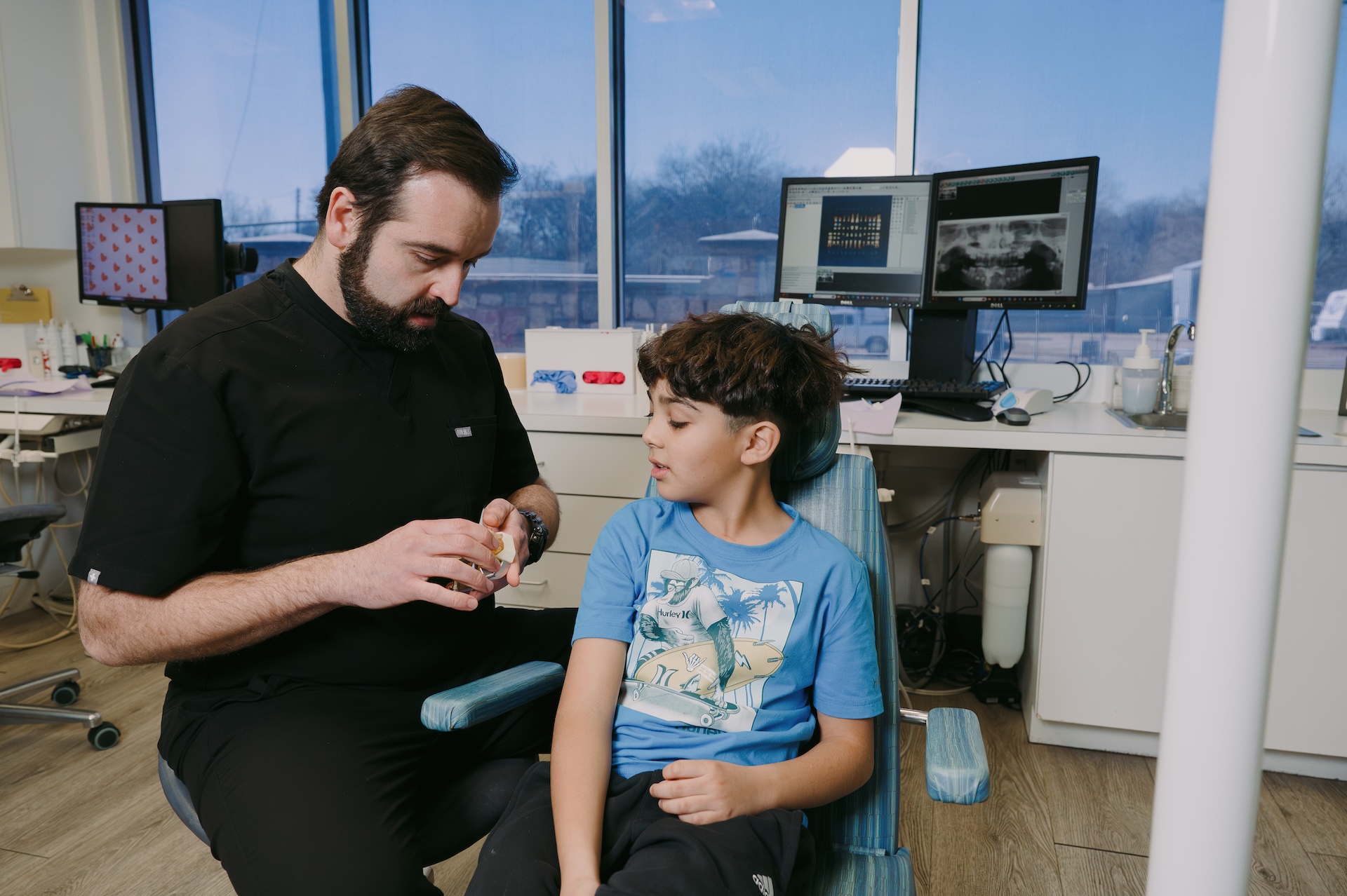 A caring pediatric dentist explaining proper oral hygiene to make dental visits fun and friendly!