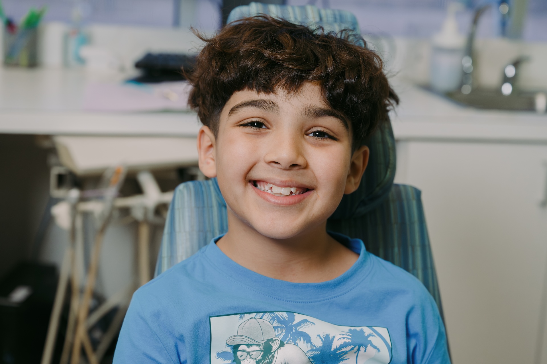 Smiling child in a dental chair after a filling at Just For Kids Dentistry, showing comfort and confidence in pediatric dental care.