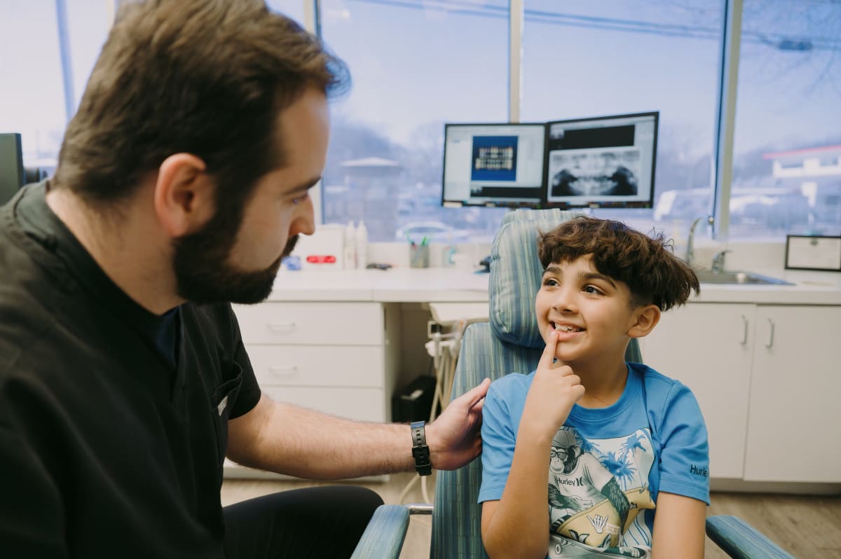 Dentist examining young child's mouth during dental visit in modern clinic