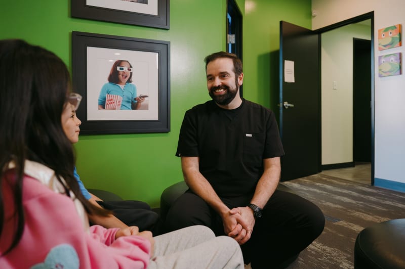 Dentist speaking with parent and child in welcoming clinical environment