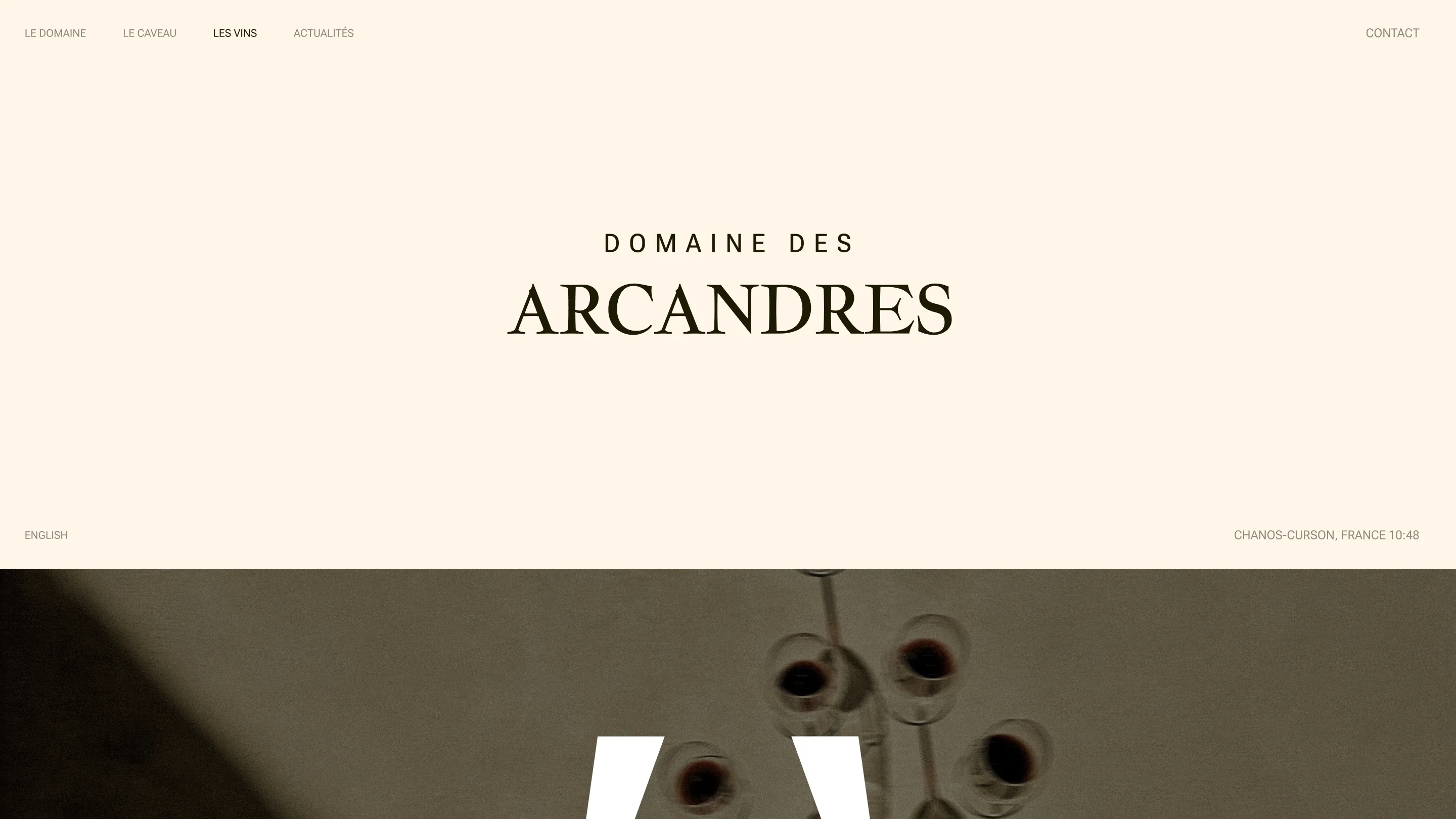 Website header for Domaine des Arcandres with menu and wine glass shadows on beige background.