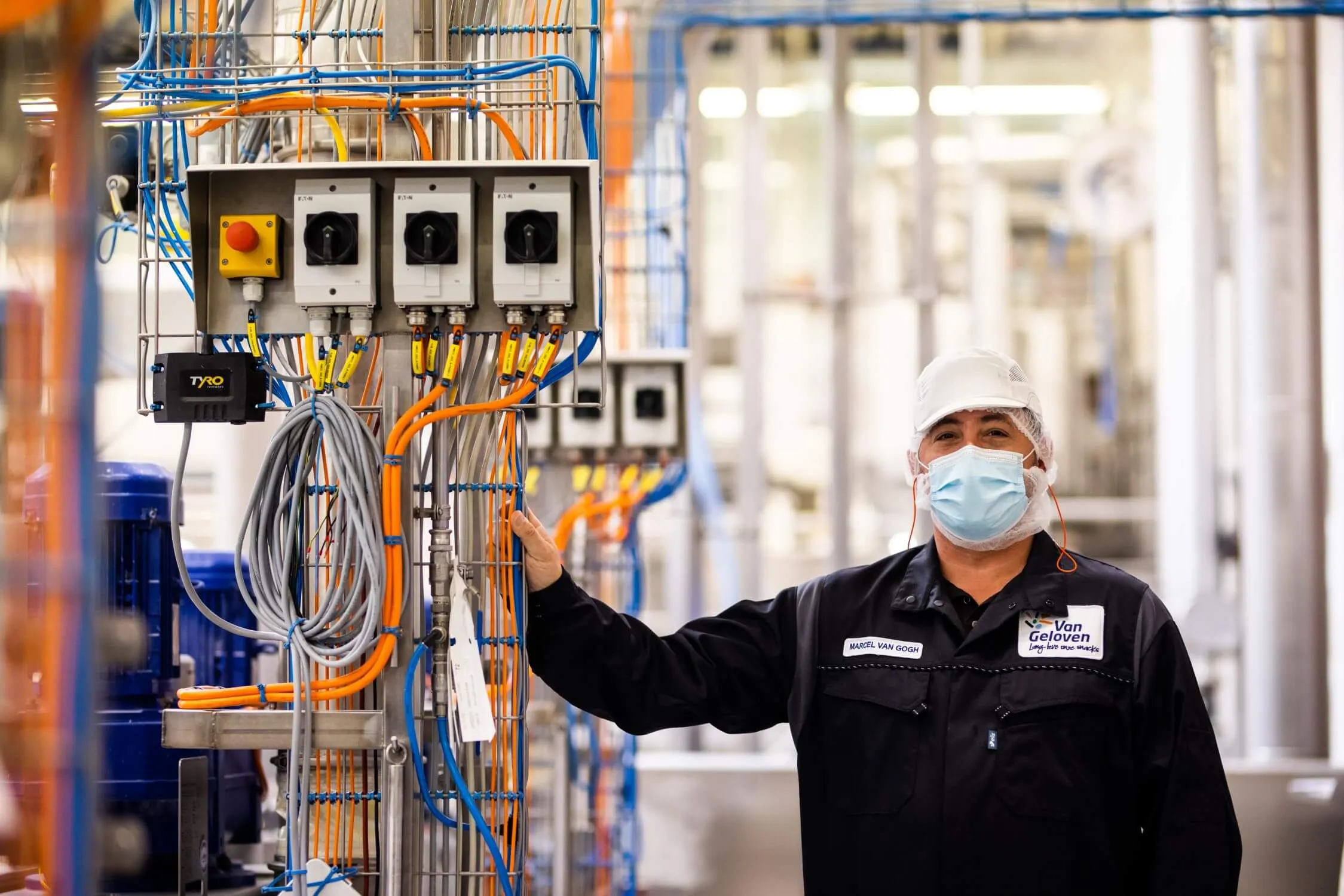 een persoon die een masker draagt en een draad voor een machine houdt
