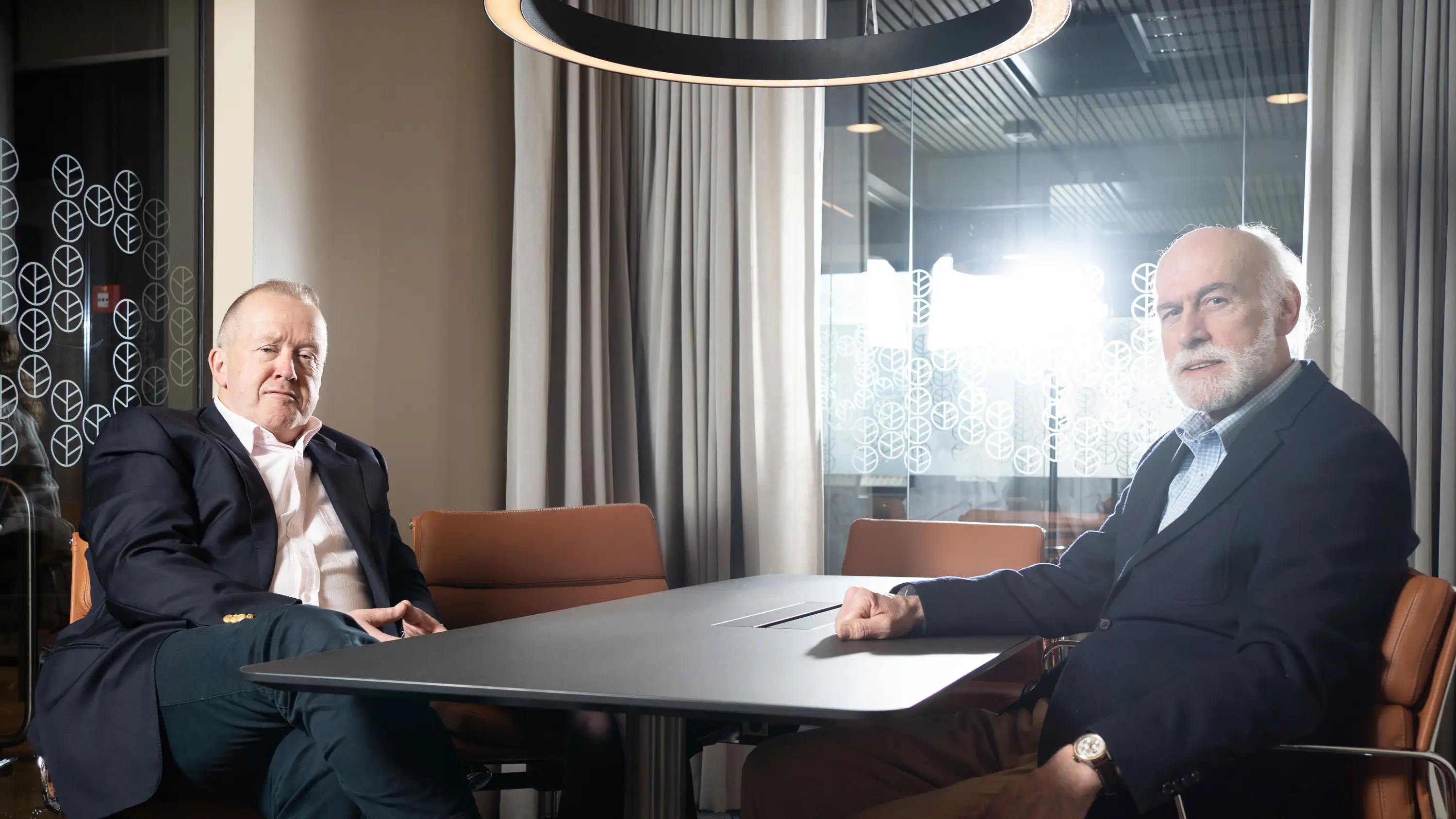 Two lawyers sitting around a meeting room table