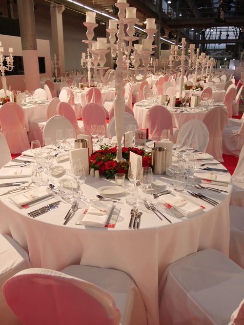 Kerzenleuchter umgeben von Blumenkranz und angelegtem Besteck