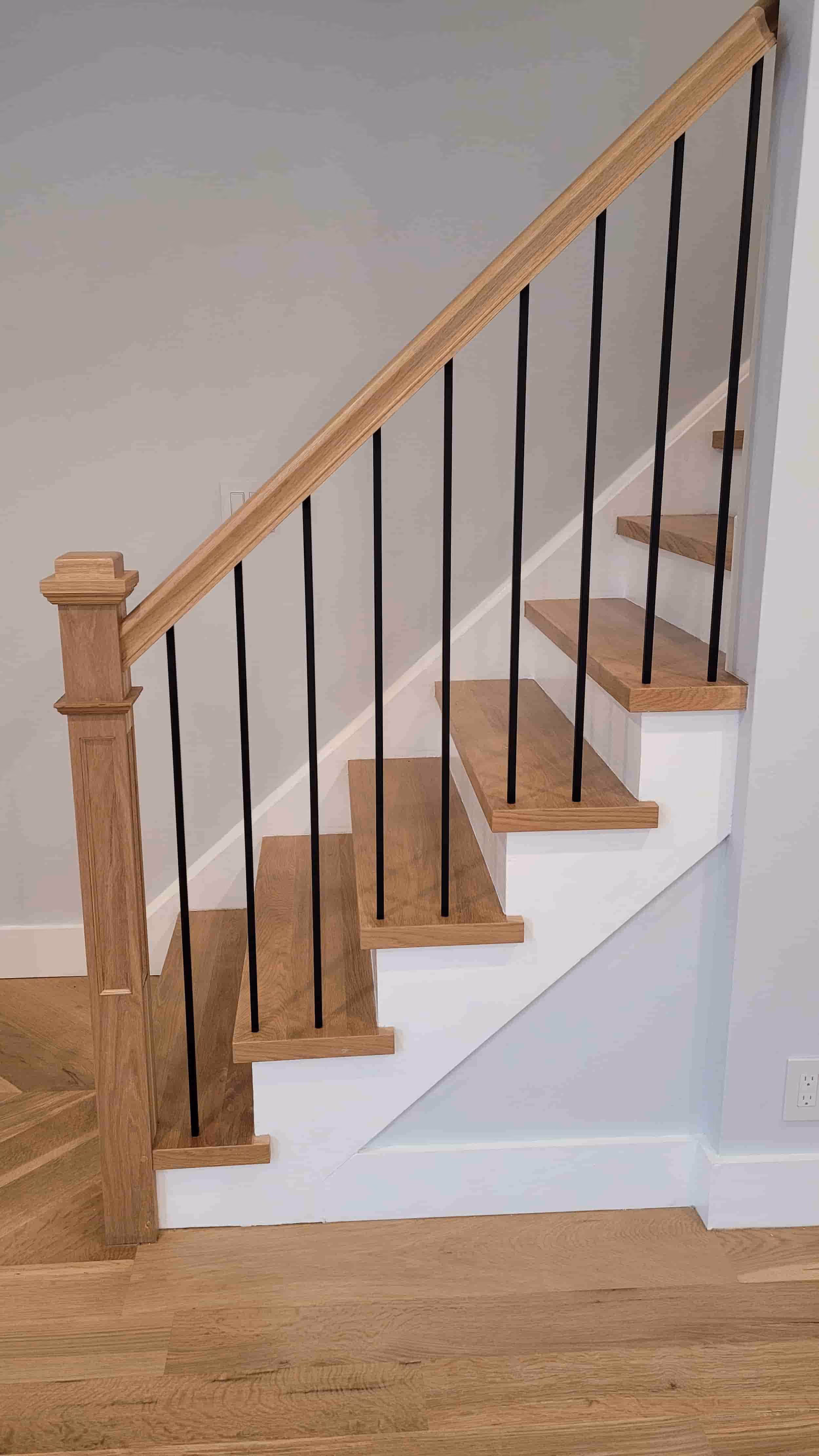 Oak staircase with white risers and black metal balusters