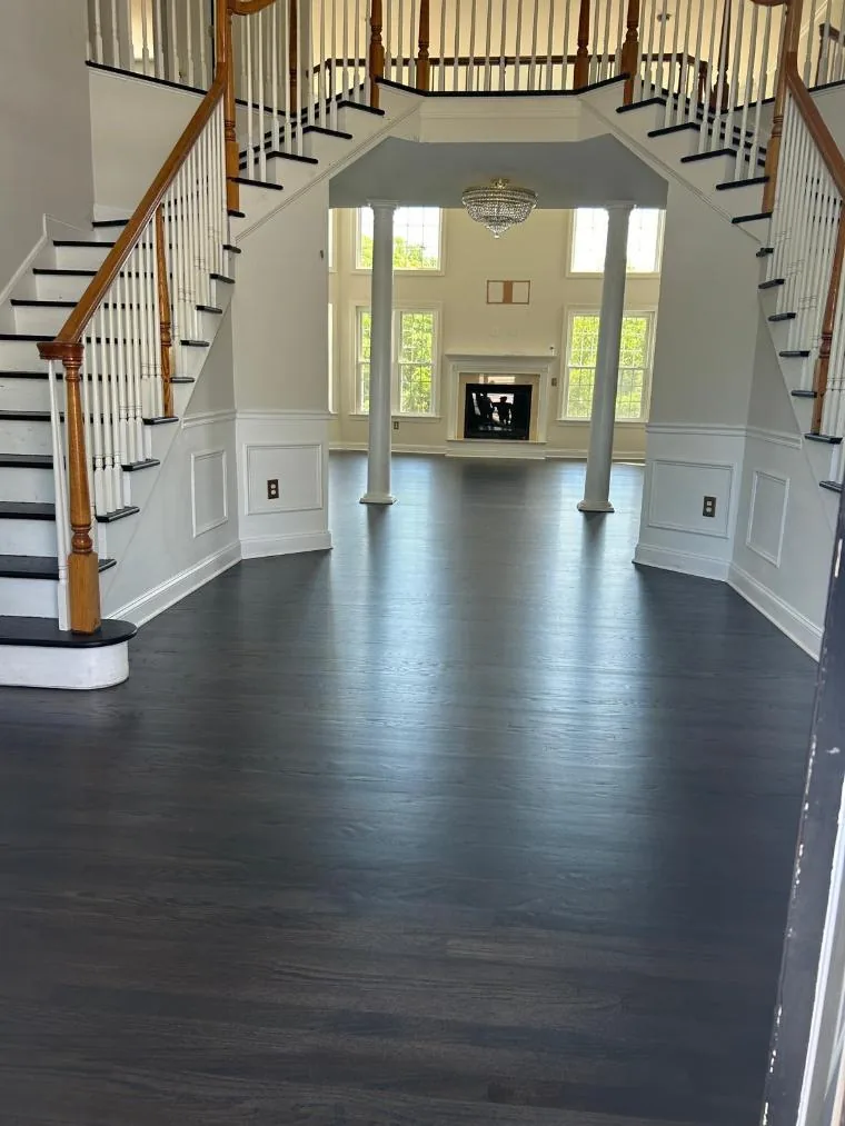 Ebony stained red oak floor in a two-story entry with white staircases