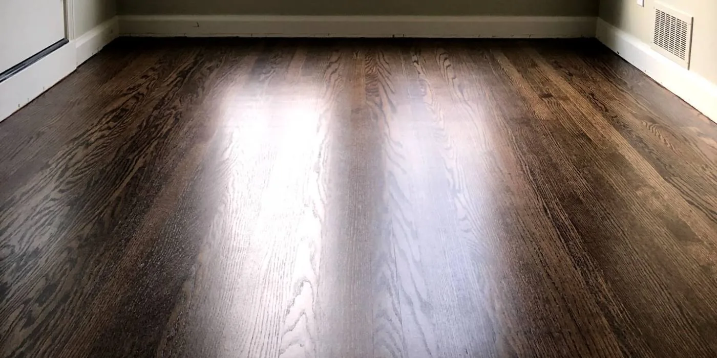 Dark stained red oak floor in a bedroom with afternoon light