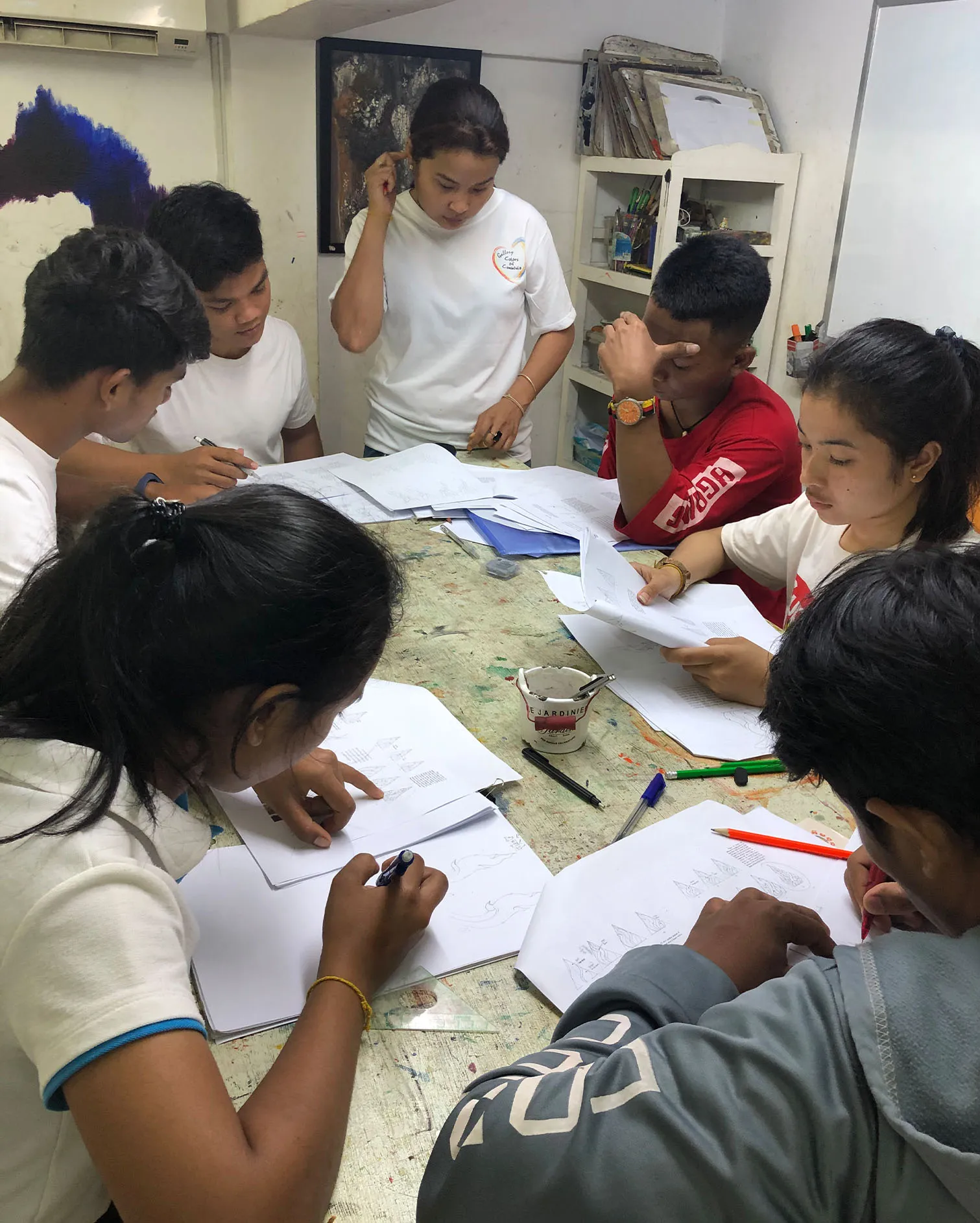 Students at Colors of Cambodia painting together.