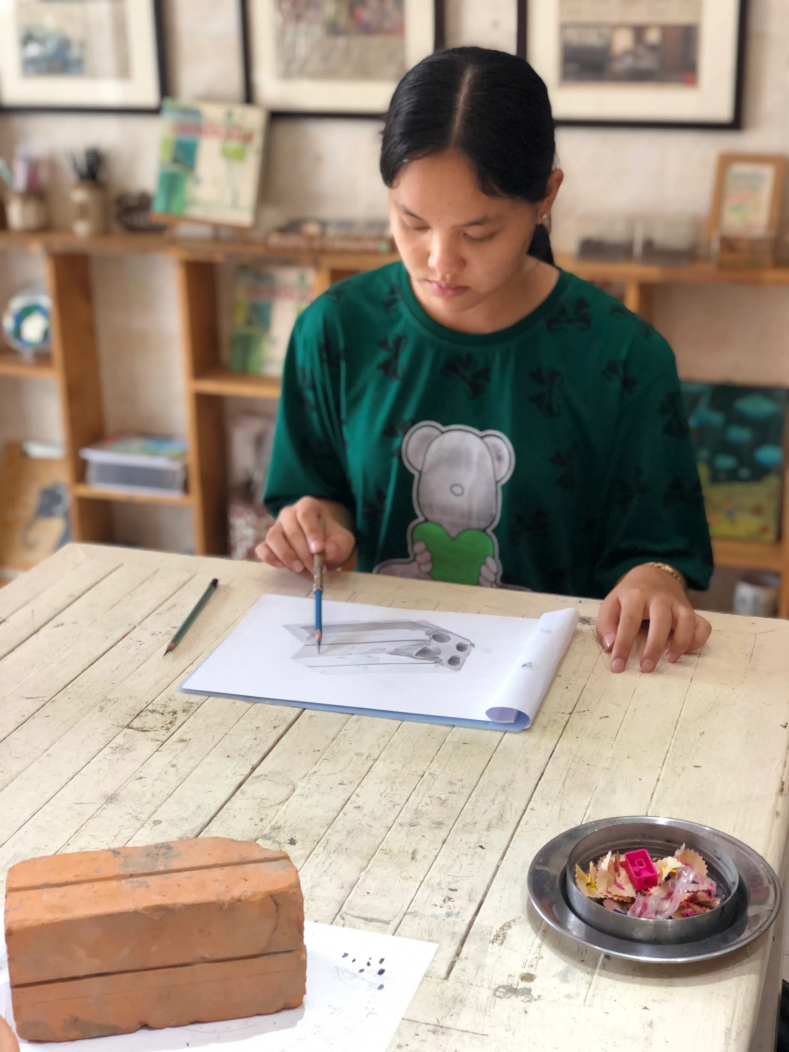 Cambodian girl doing a pencil drawing.