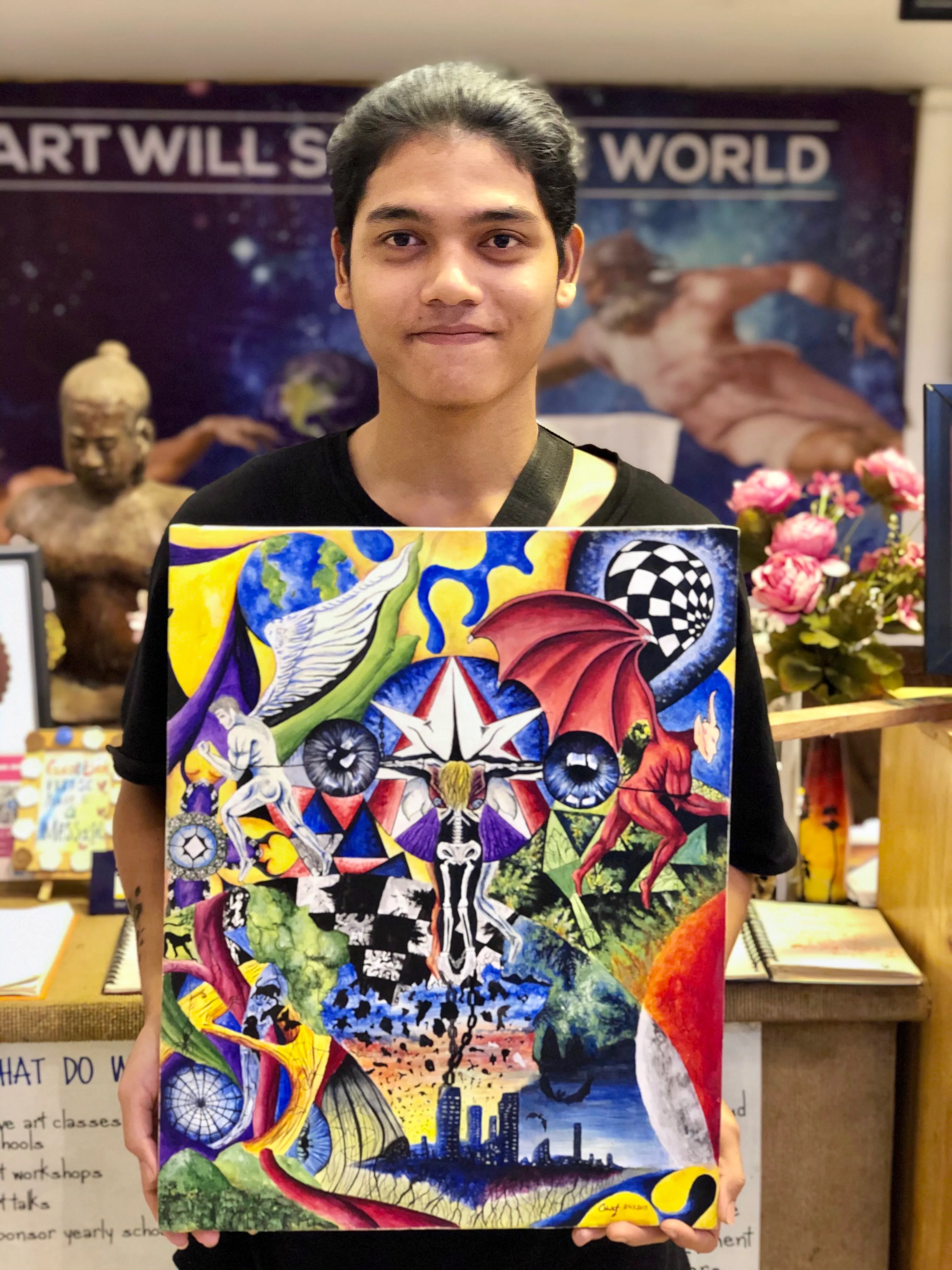 Colors of Cambodia student holding up his art work.