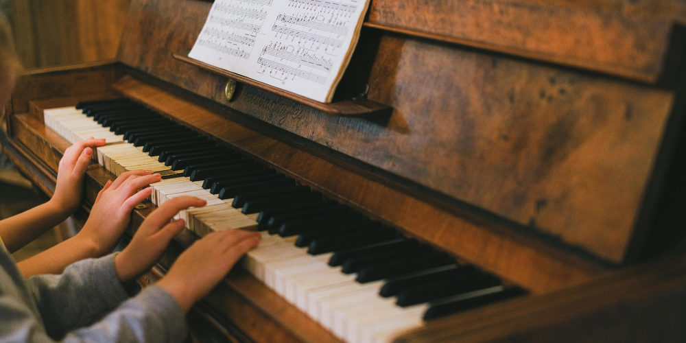 children learning to play the piano, reading music notes