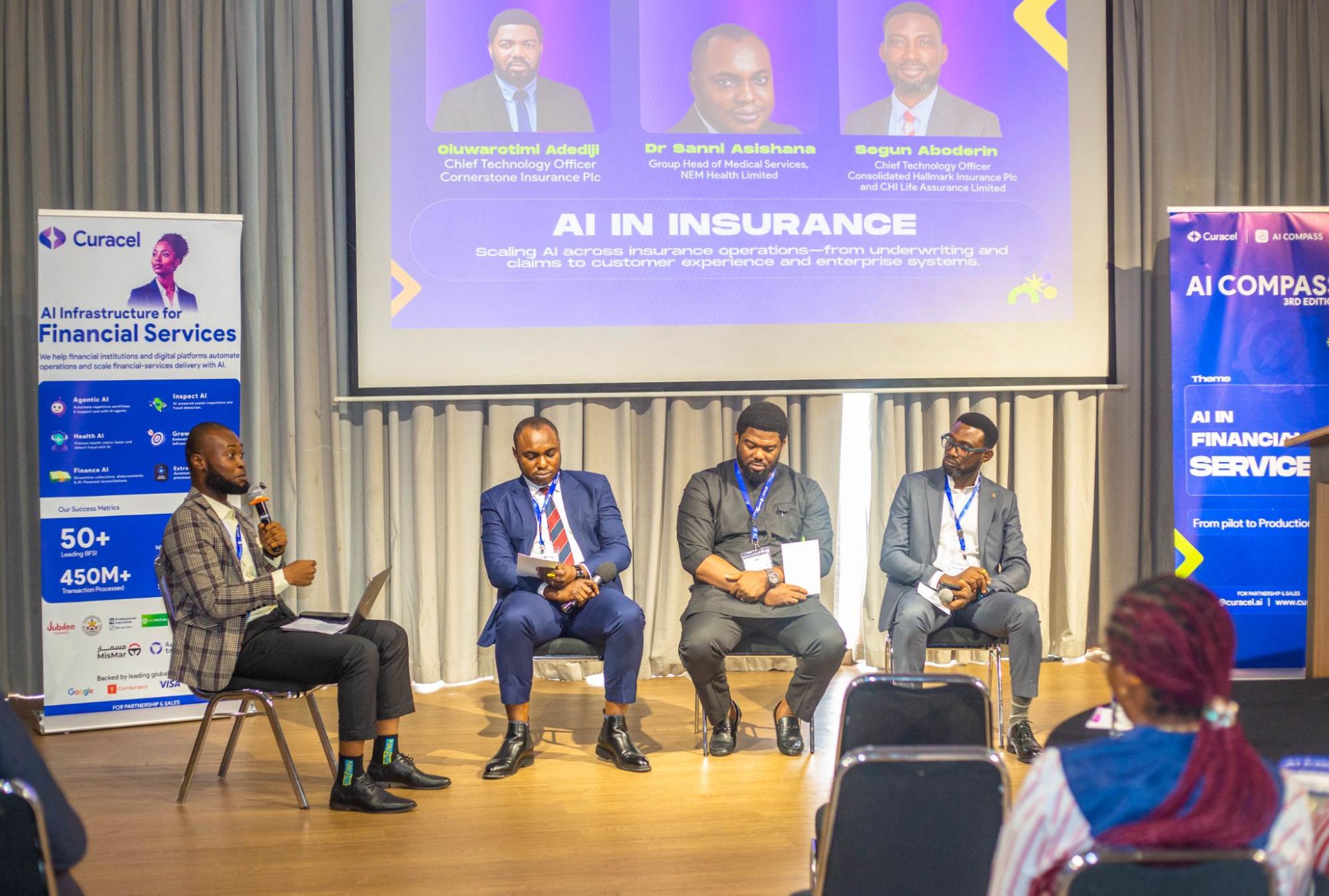 Four panel participants seated on stage beneath a screen displaying AI in Insurance.