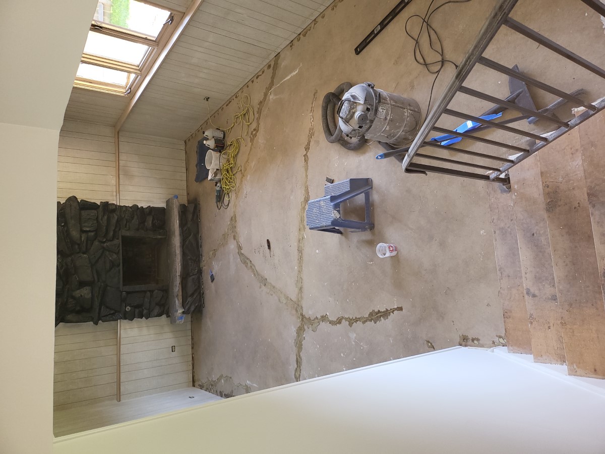 Unfinished basement room with a bare cracked concrete floor