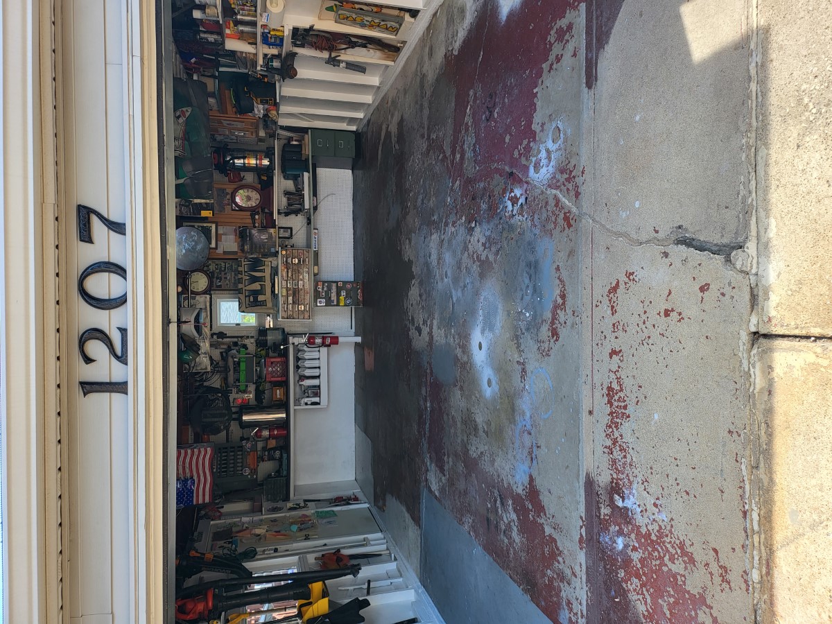 Garage floor with worn, peeling coating before removal