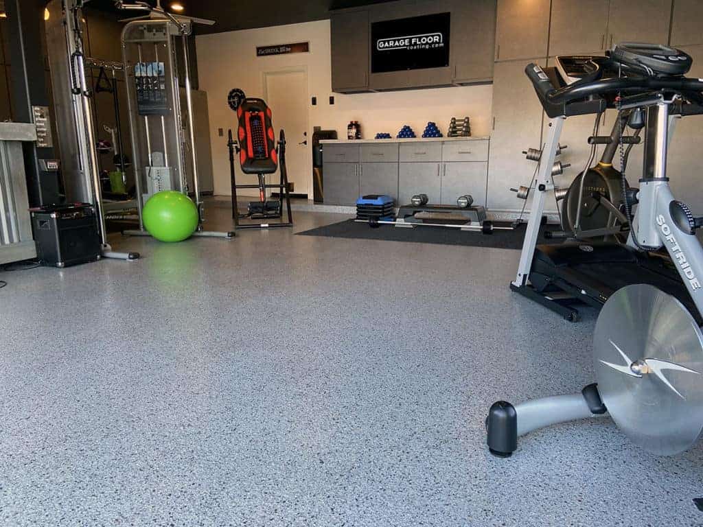 Home gym with a gray epoxy flake floor and exercise equipment
