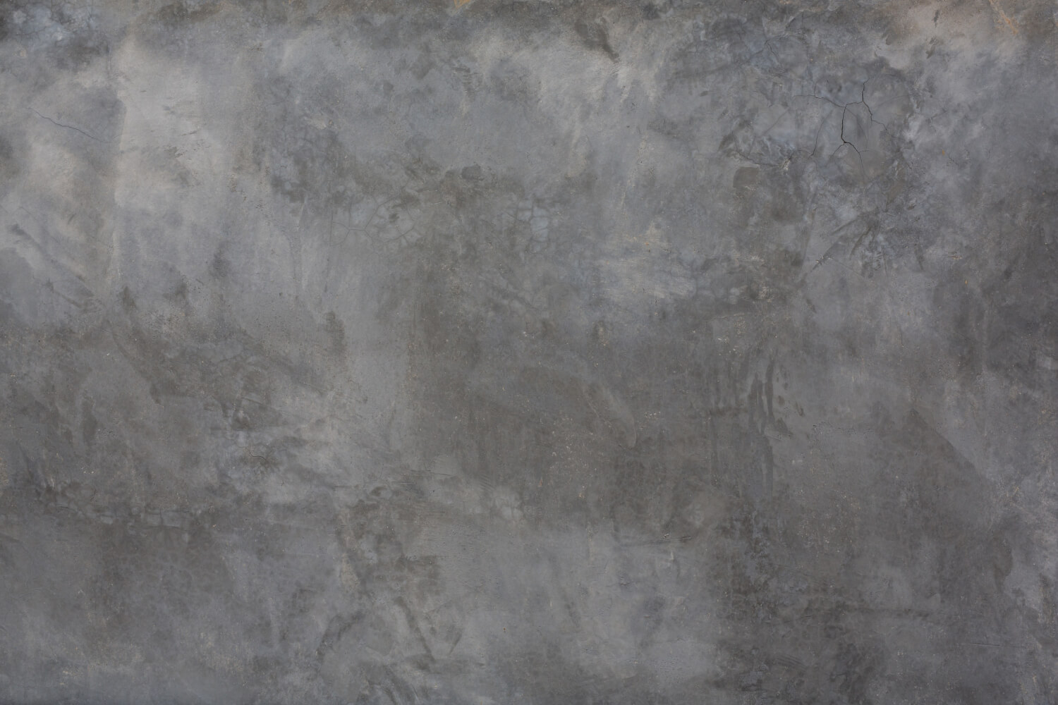 Untreated concrete slab with varied shades where pours meet