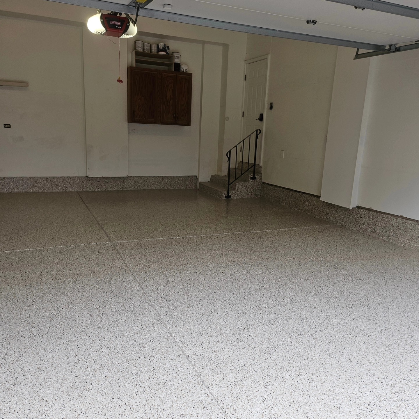 Coated garage floor with steps leading up to the door into the house