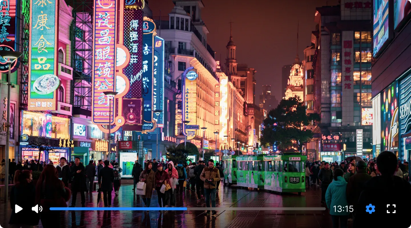Video-Player-Screenshot einer beleuchteten chinesischen Straße mit Passanten und Neon-Beschilderung