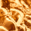 Close-up of brown sand particles on a wire mesh, against a blue background.