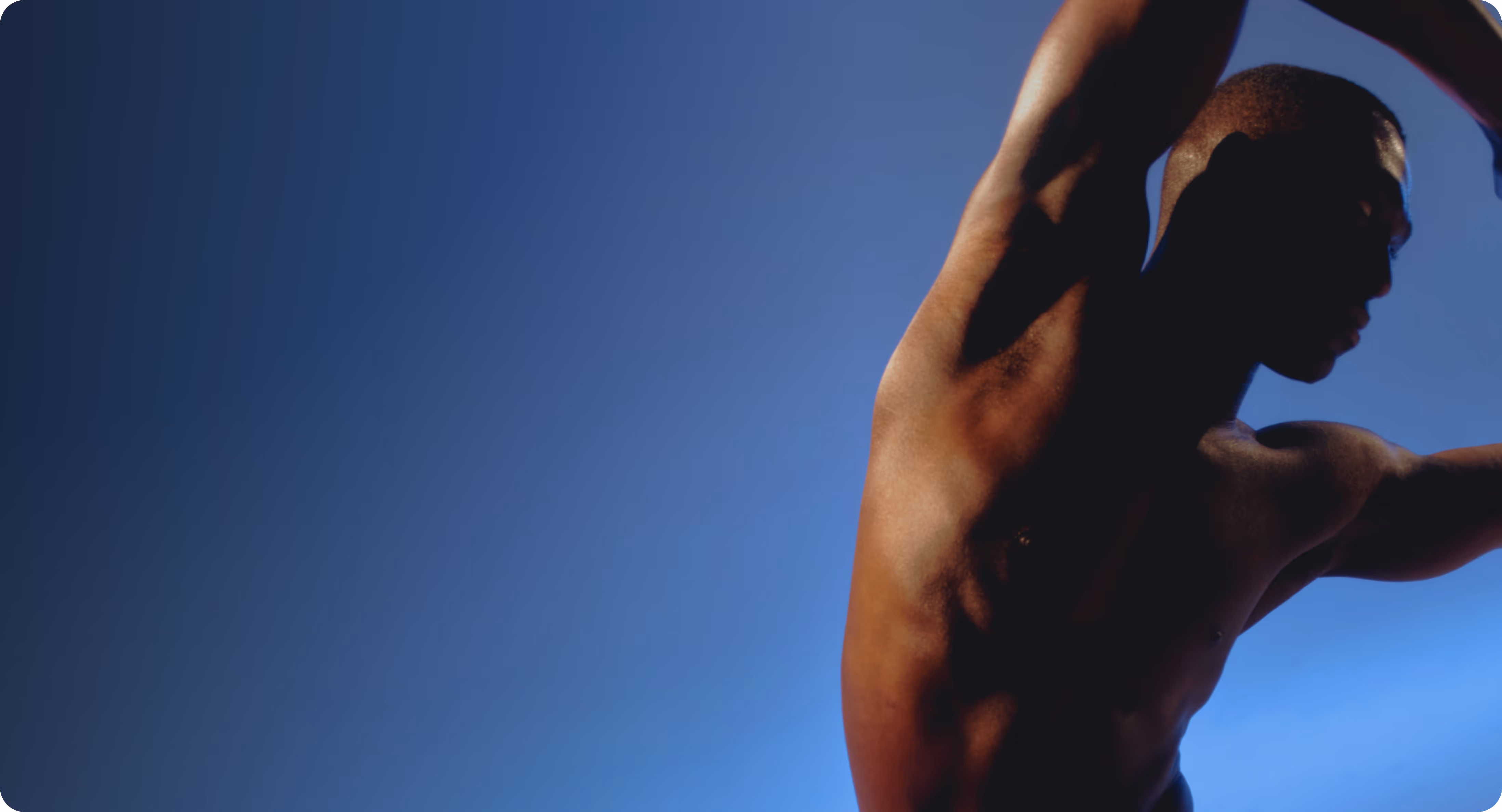 A person stretches their arm upward against a plain blue background.