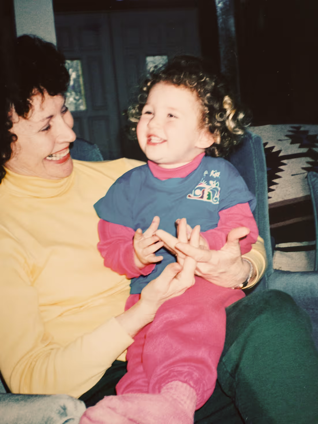 Smiling young woman carrying her child, 1980s