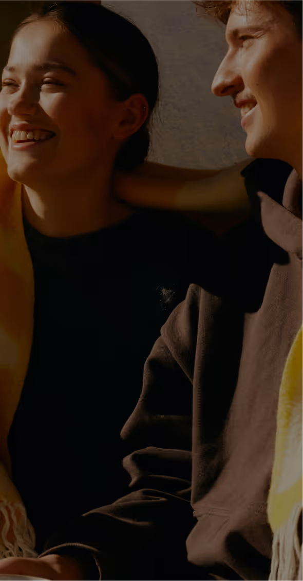 Couple wrapped in a blanket, smiling