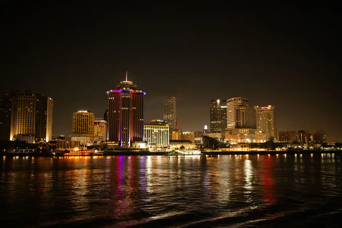 New Orleans skyline lit up at night across the Mississippi River