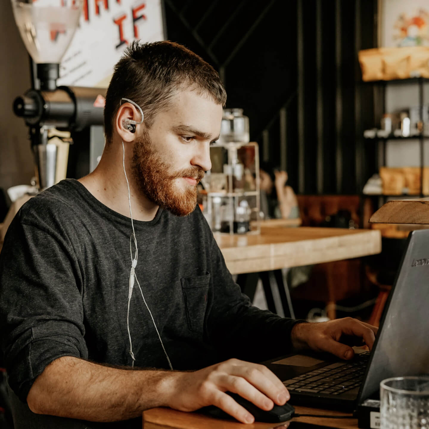 A man sitting at a table using a laptop computer