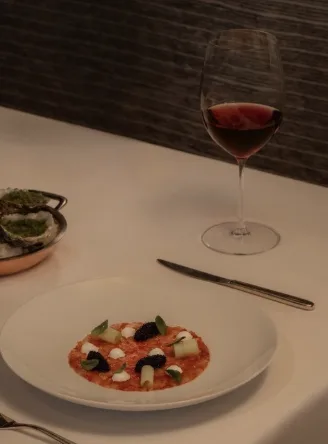 Reference photograph of a plated dish and a glass of red wine.