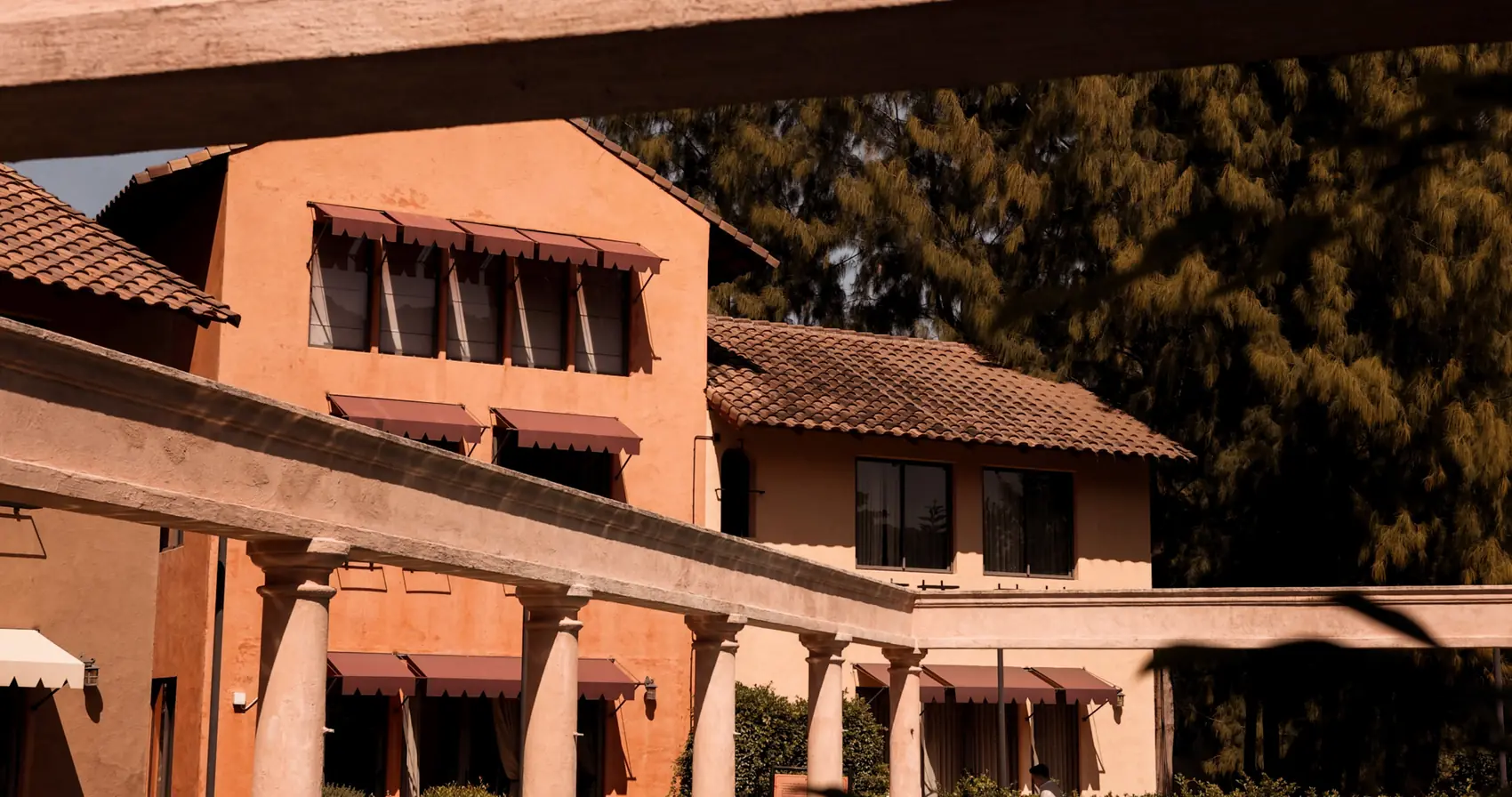 Awnings and terracotta façades seen through the colonnade.