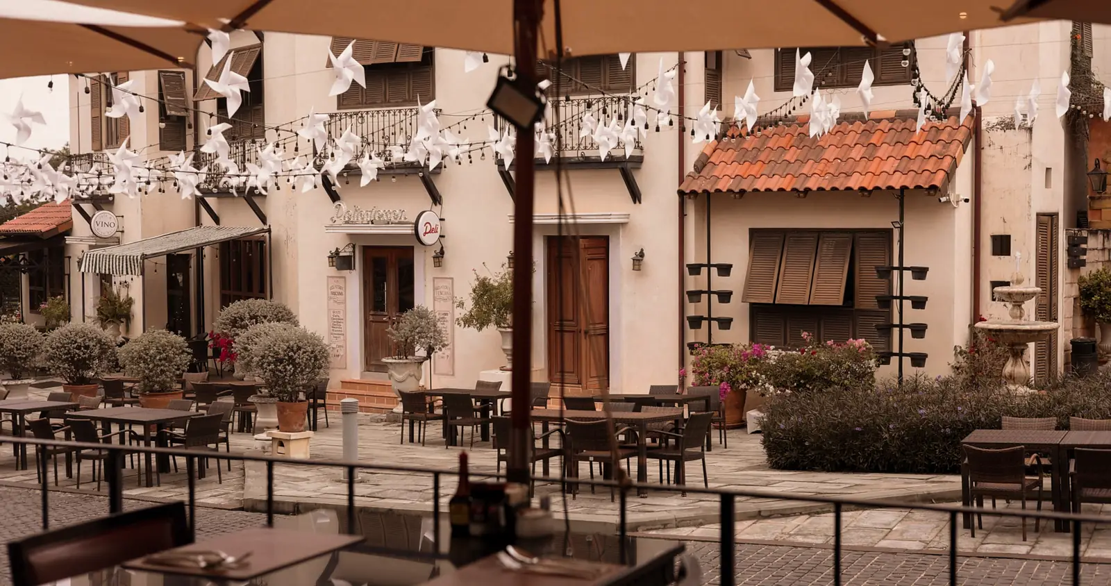 The plaza seen from under an umbrella, with pinwheels strung above the terrace.