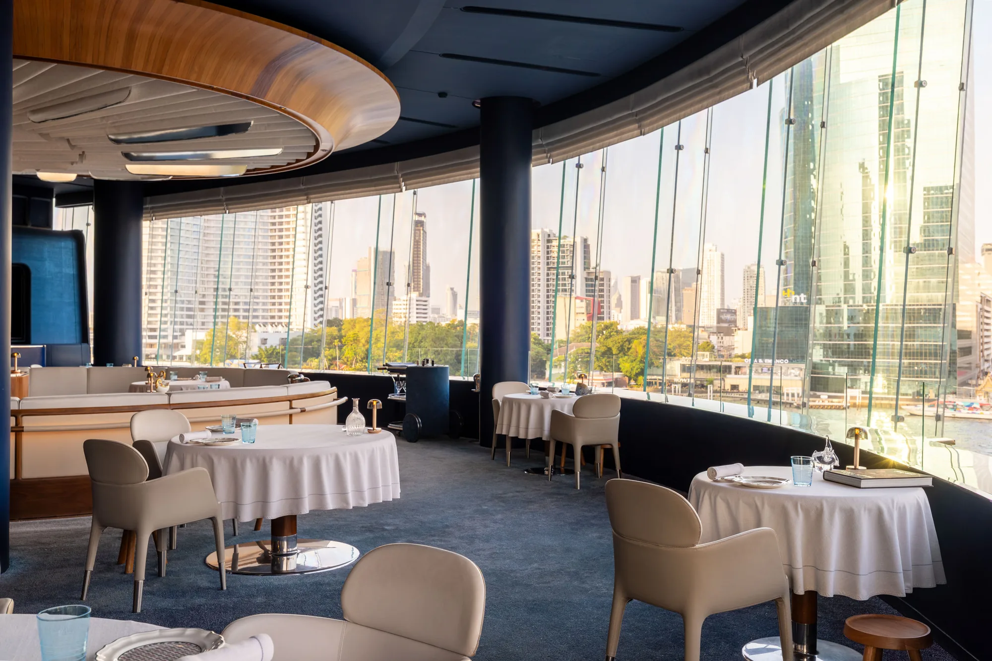 Window-side tables at BLUE overlooking the Bangkok skyline.