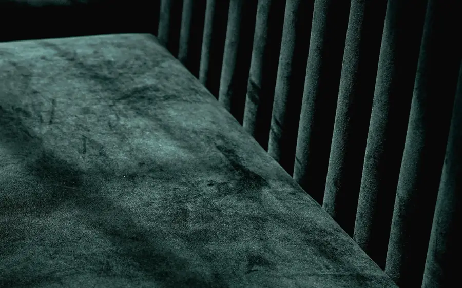 Green velvet banquette in low light