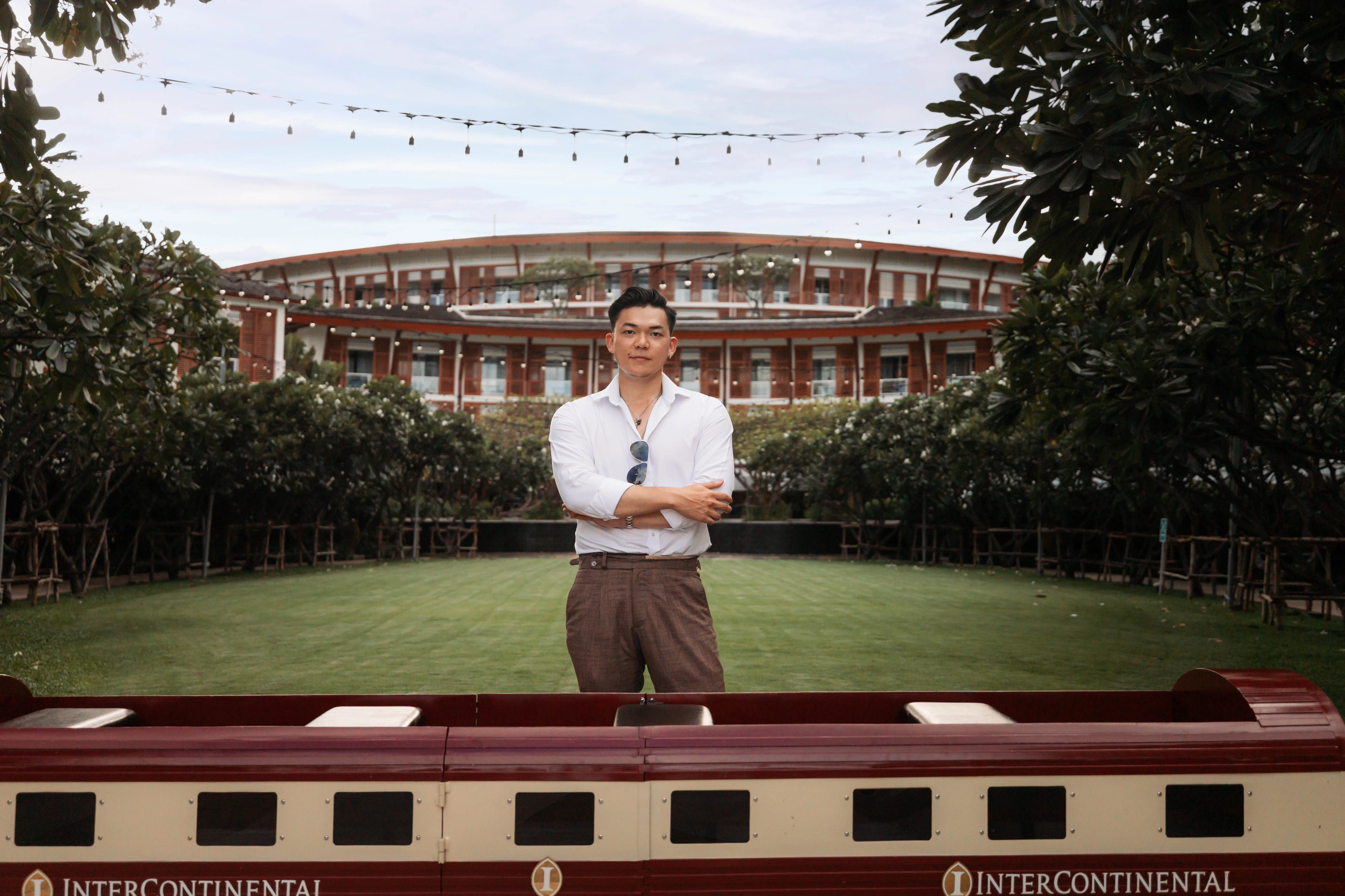 A guest in sunglasses and a white shirt on the resort lawn