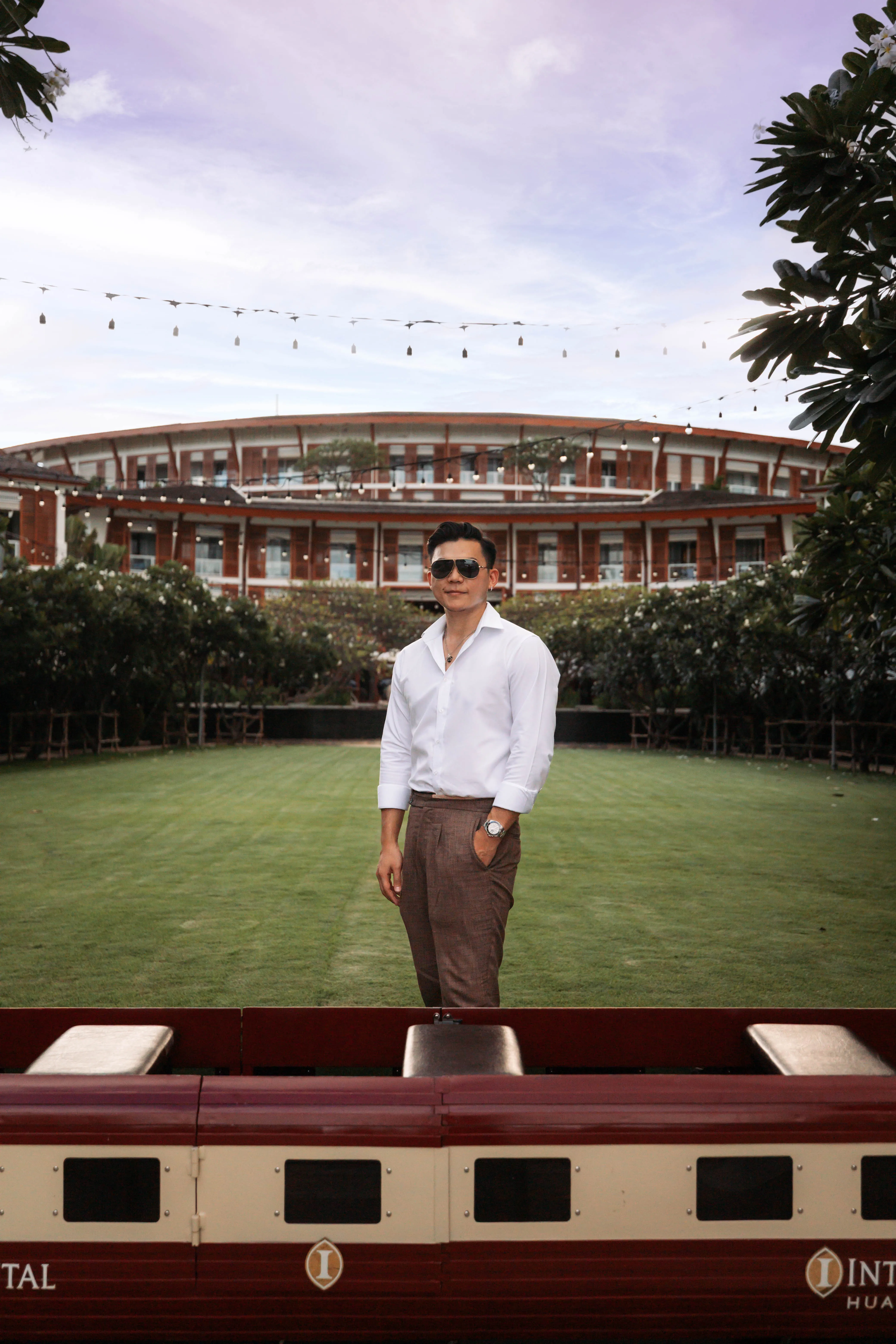 A guest standing on the lawn at InterContinental Hua Hin Resort in sunglasses and a white shirt