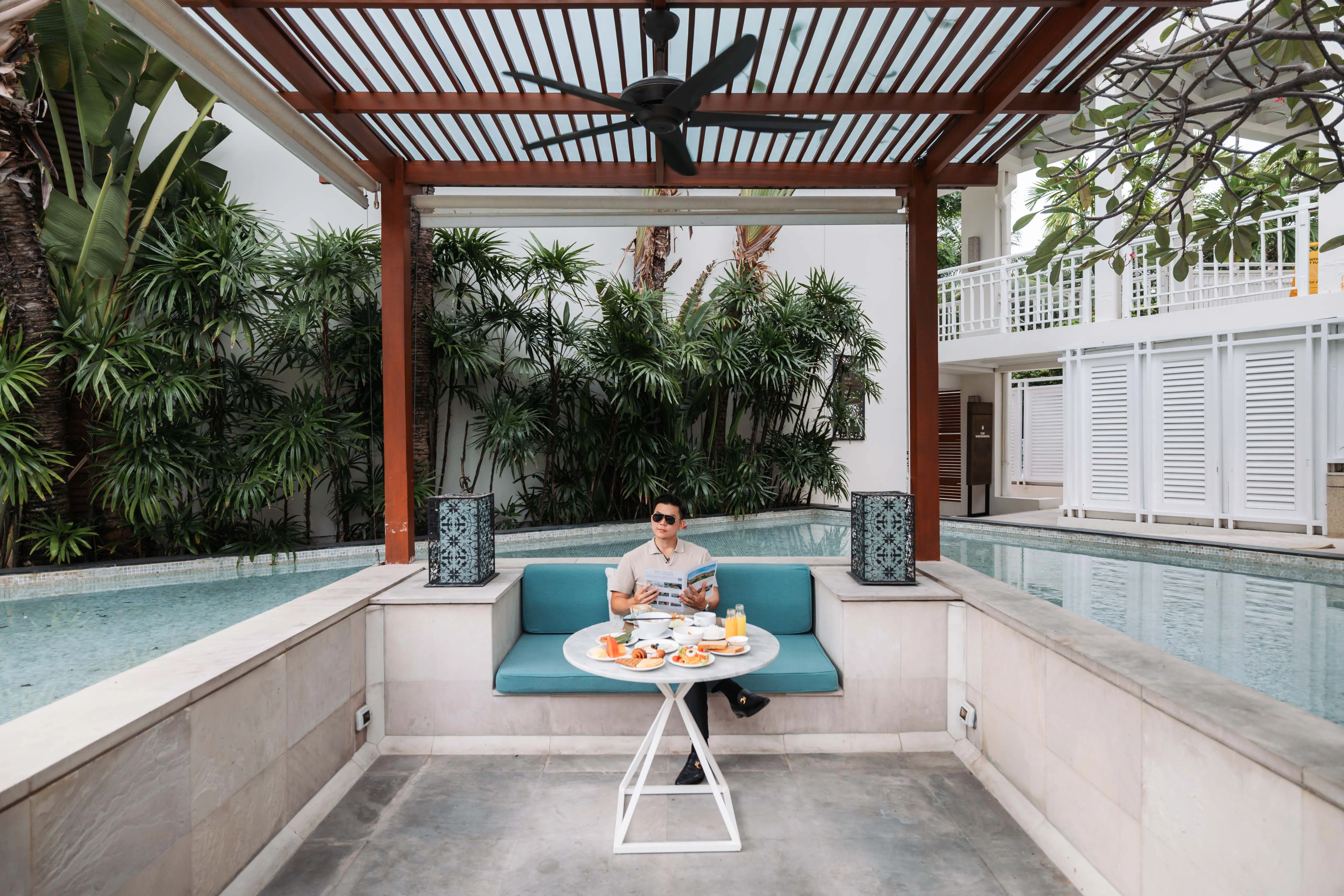 Poolside seating and a breakfast table at the beachfront villa