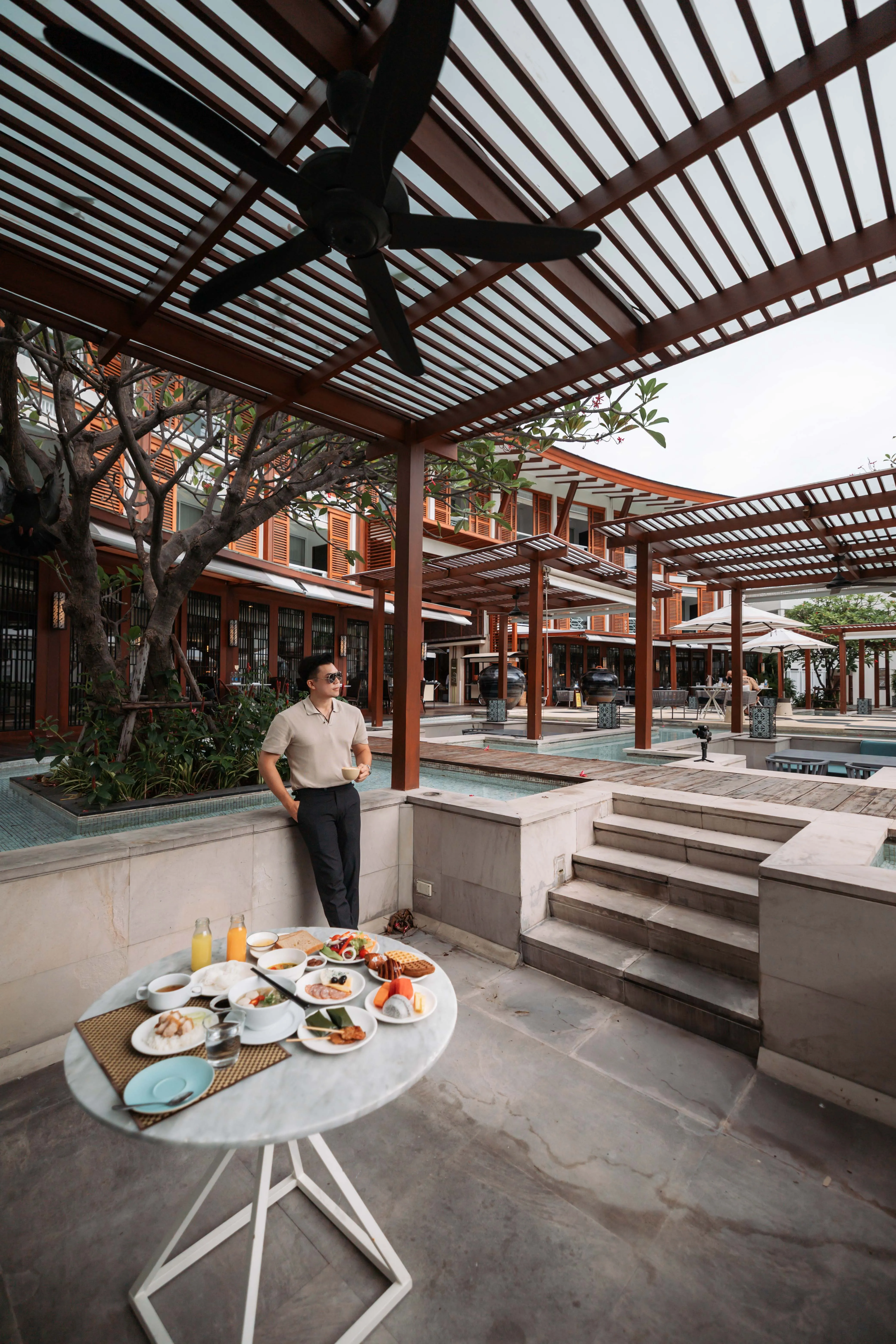 A table laid for breakfast beneath a timber pergola at the resort