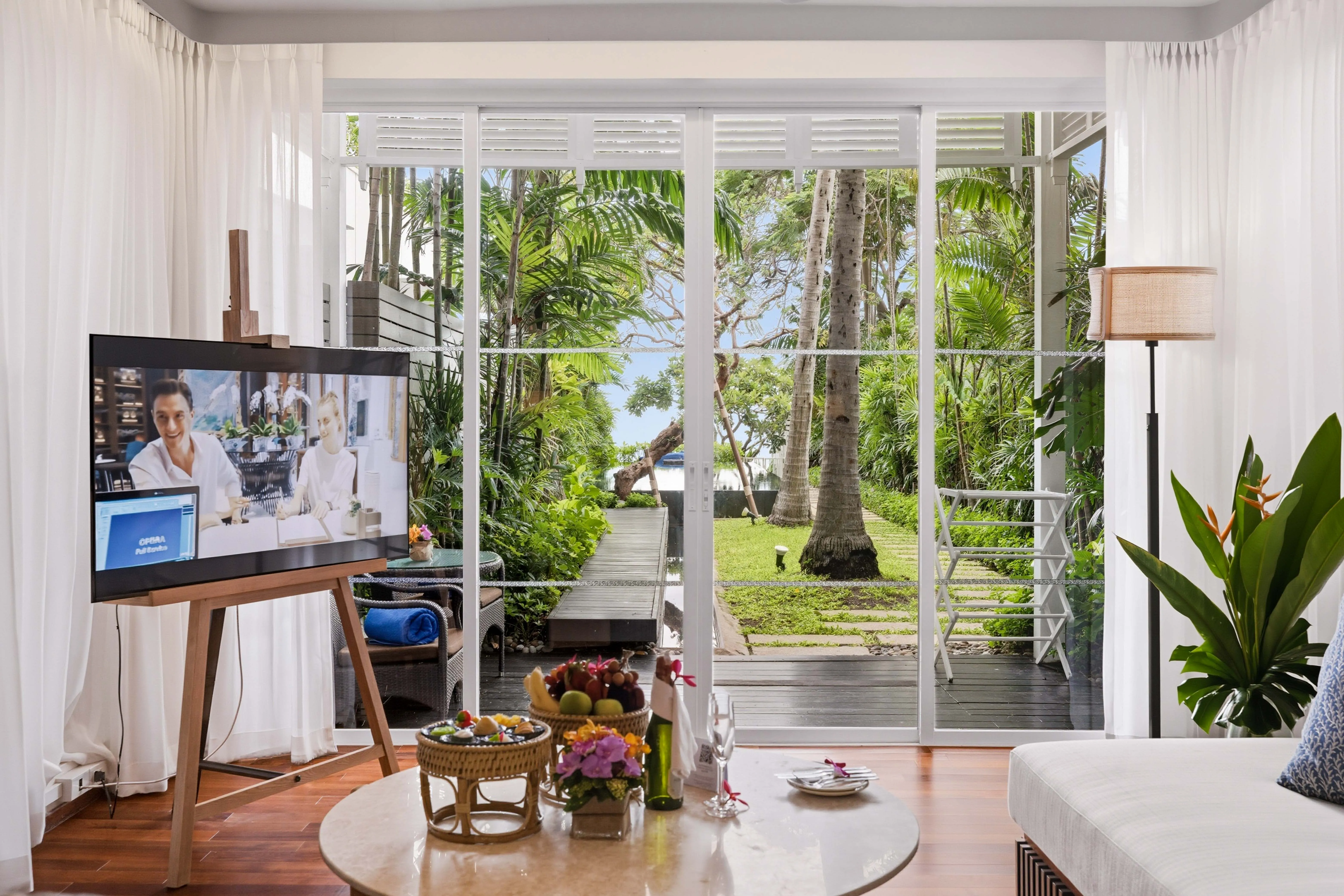 The villa living room opening onto a garden path to the sea