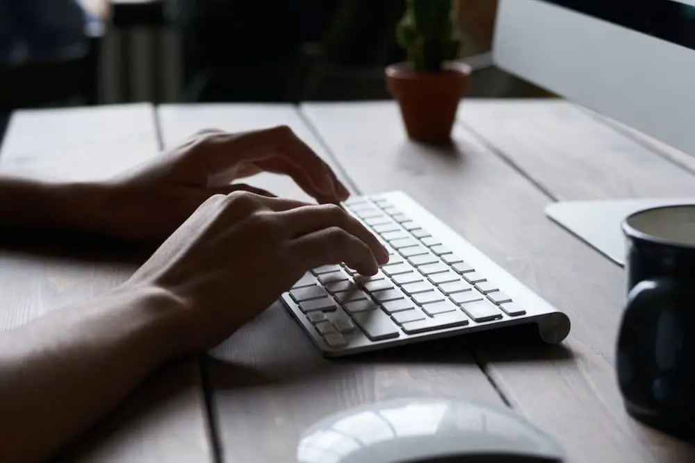 an image of a person's hands working on a laptop