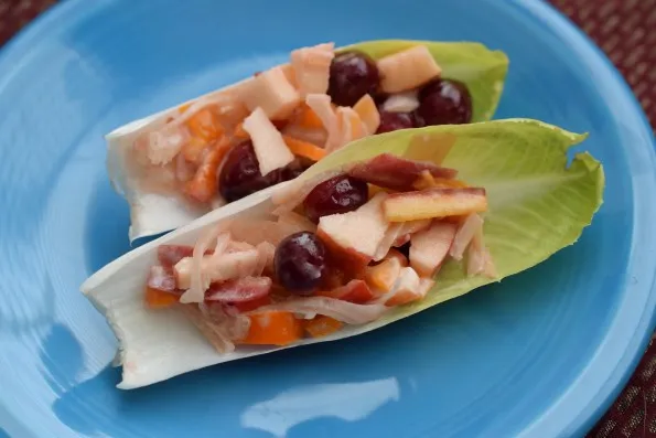 cranberry apple sauerkraut slaw in lettuce leaf appetizers on plate