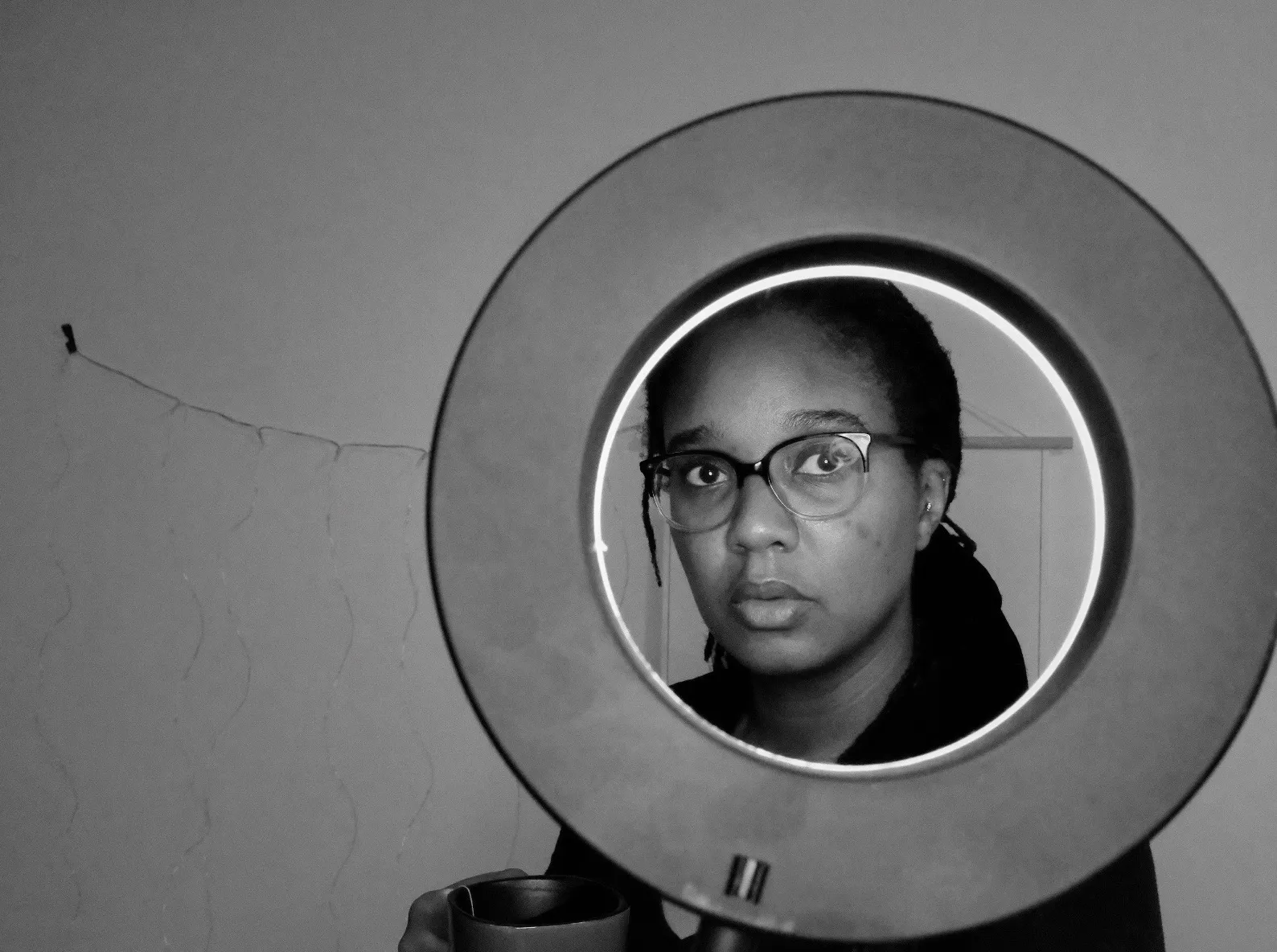 a woman looking through a ring light